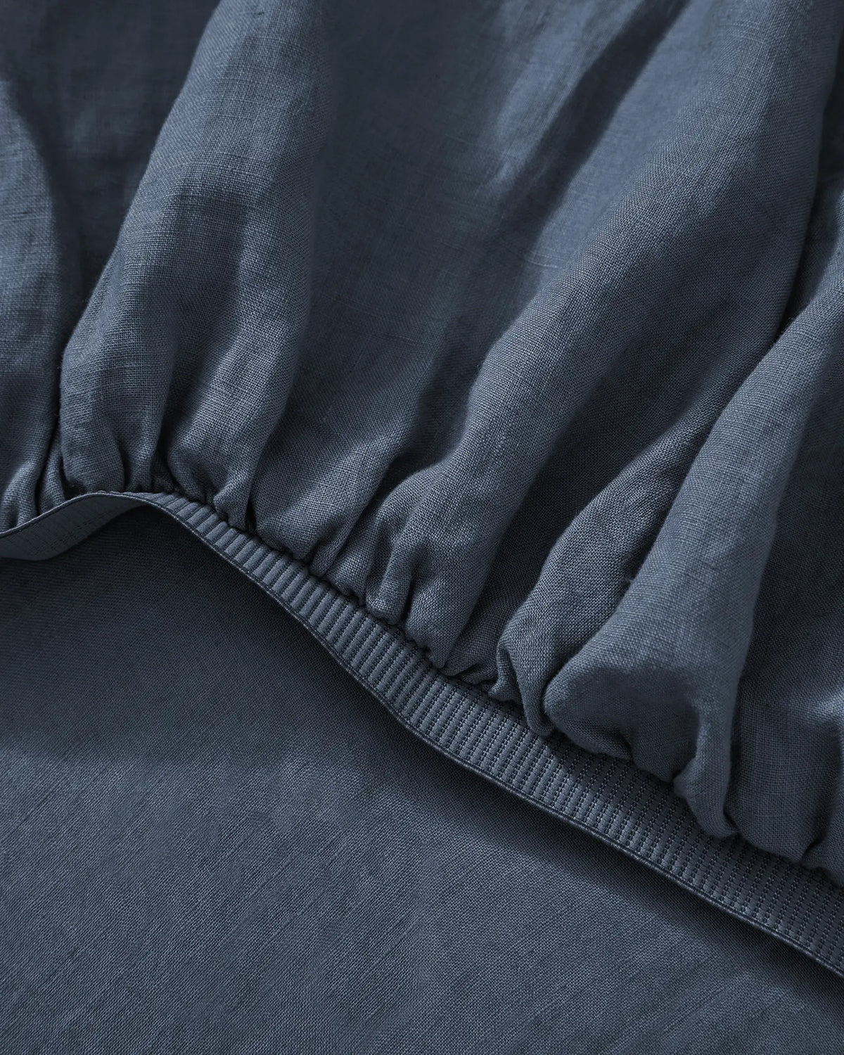 Ravello Fitted Sheet in Denim, close-up detail of elastic binding and French Flax Linen weave by Weave Home