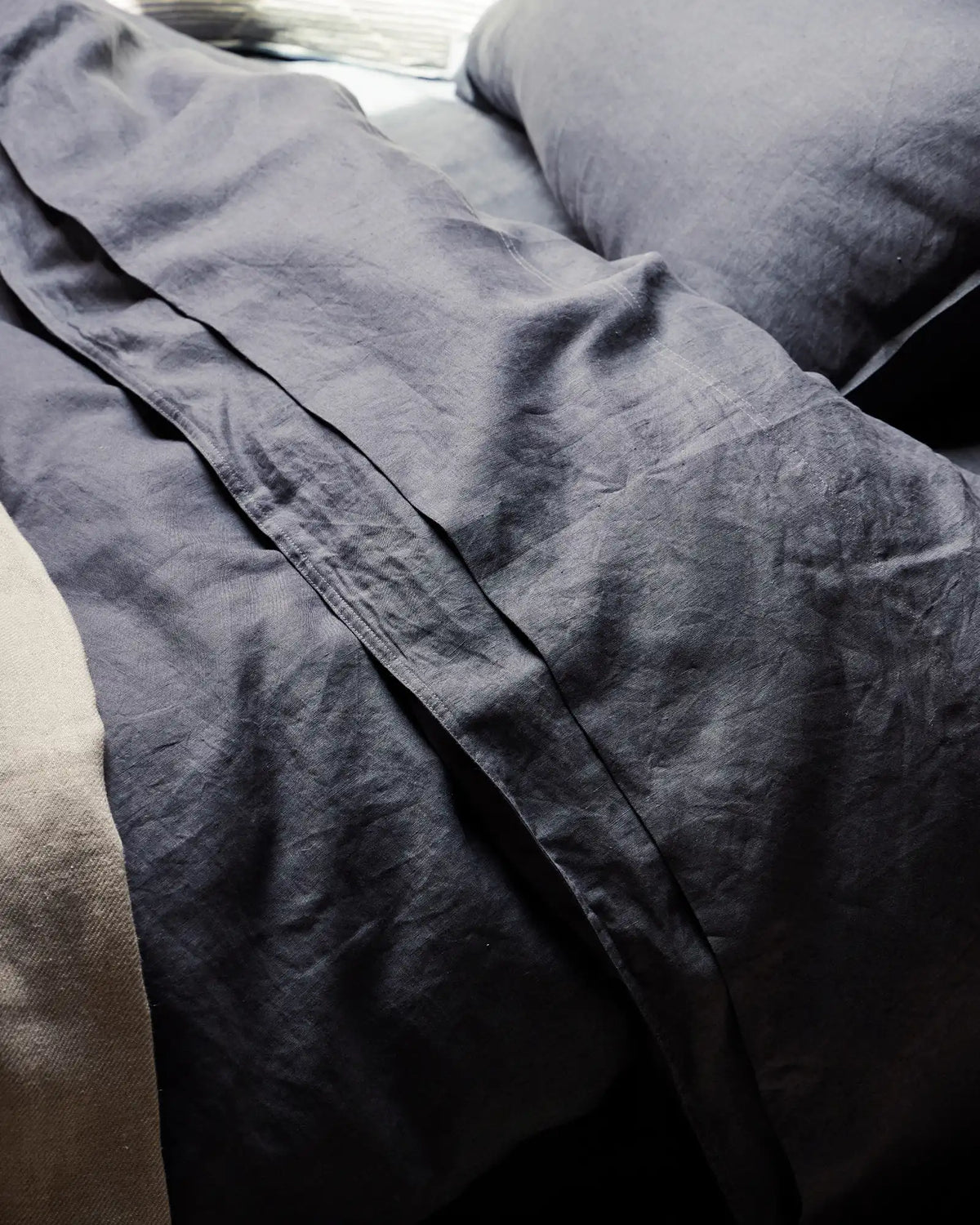 Ravello Fitted Sheet in denim European linen, detail view showing soft prewashed texture and deep side seam, by Weave Home