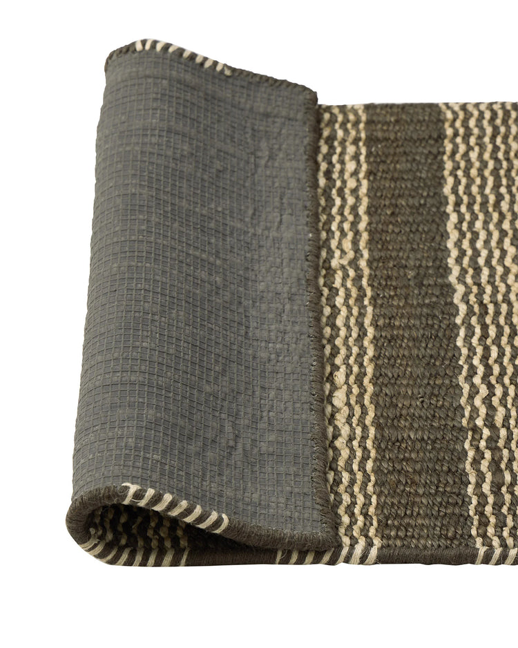 Arden Coal hand-woven jute door mat detail, showing charcoal base with cream irregular stripe border, 65x120cm by Weave Home