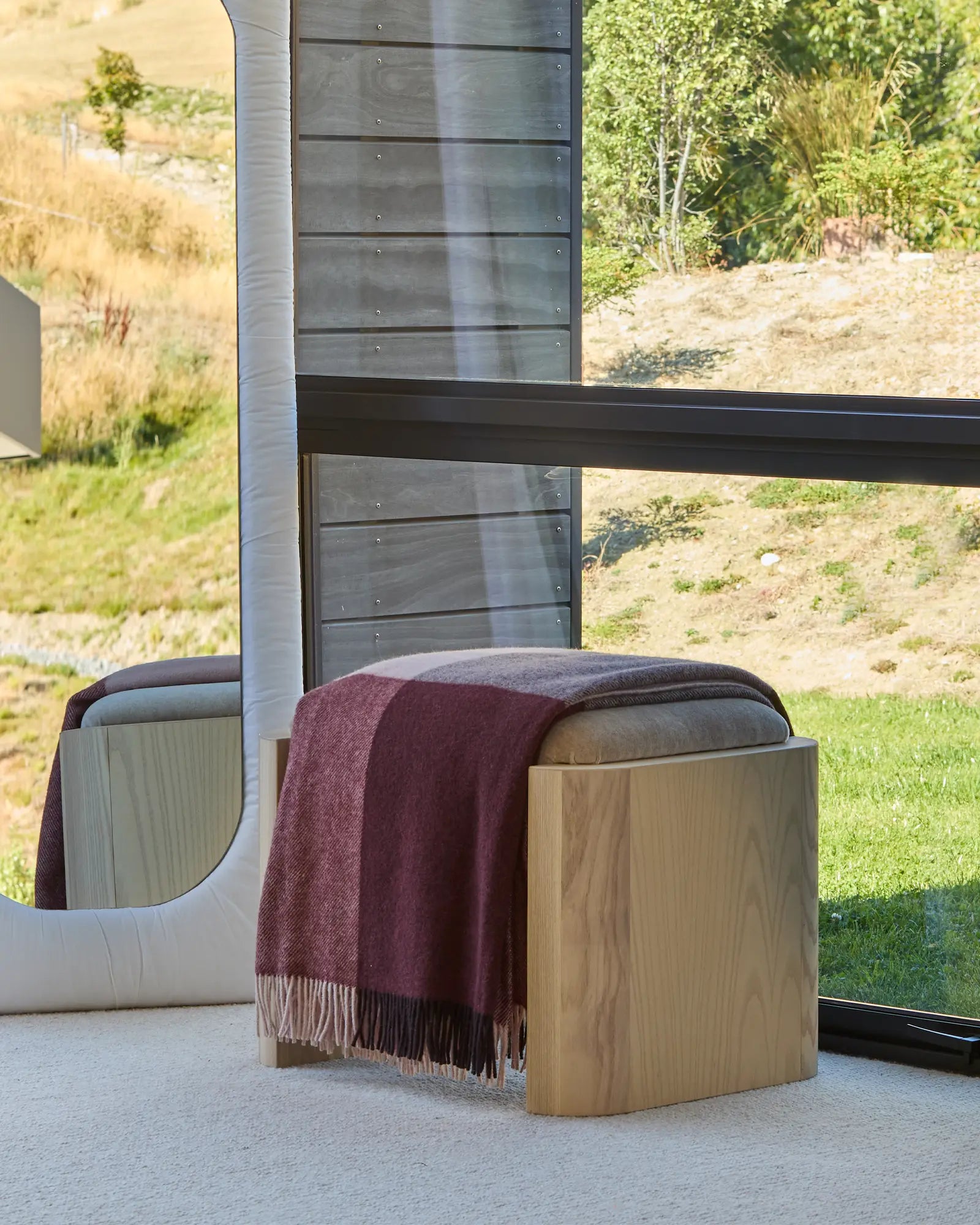 Syracuse Brookside Beetroot throw in berry and chocolate check with fringe trim, draped over wooden stool by Weave Home