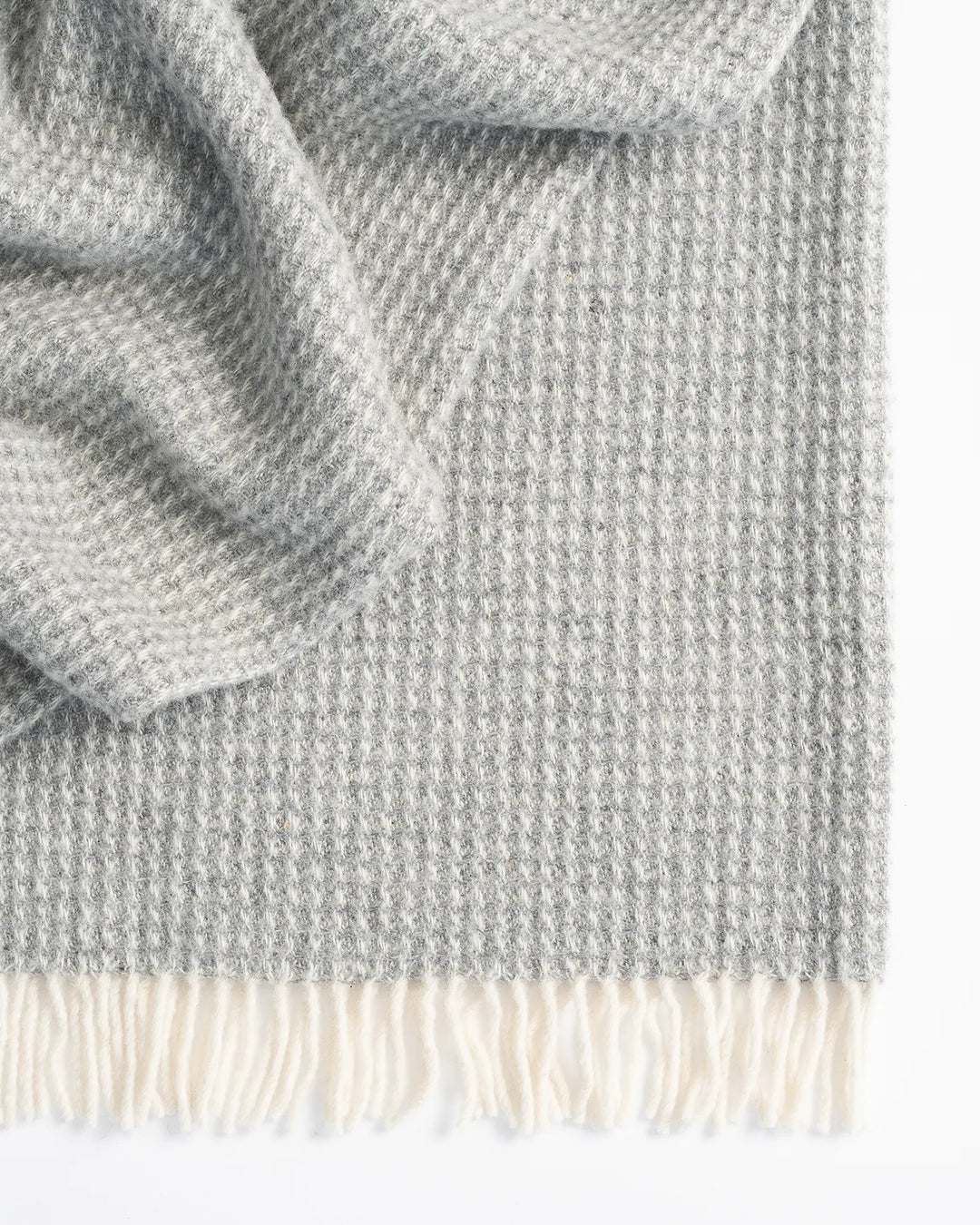 Breckon Fog waffle weave wool throw detail, showing soft grey NZ wool texture and cream fringe edge by Weave Home