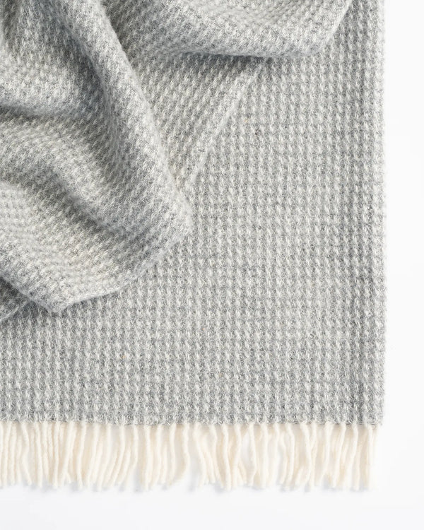 Breckon Fog waffle weave wool throw detail, showing soft grey NZ wool texture and cream fringe edge by Weave Home