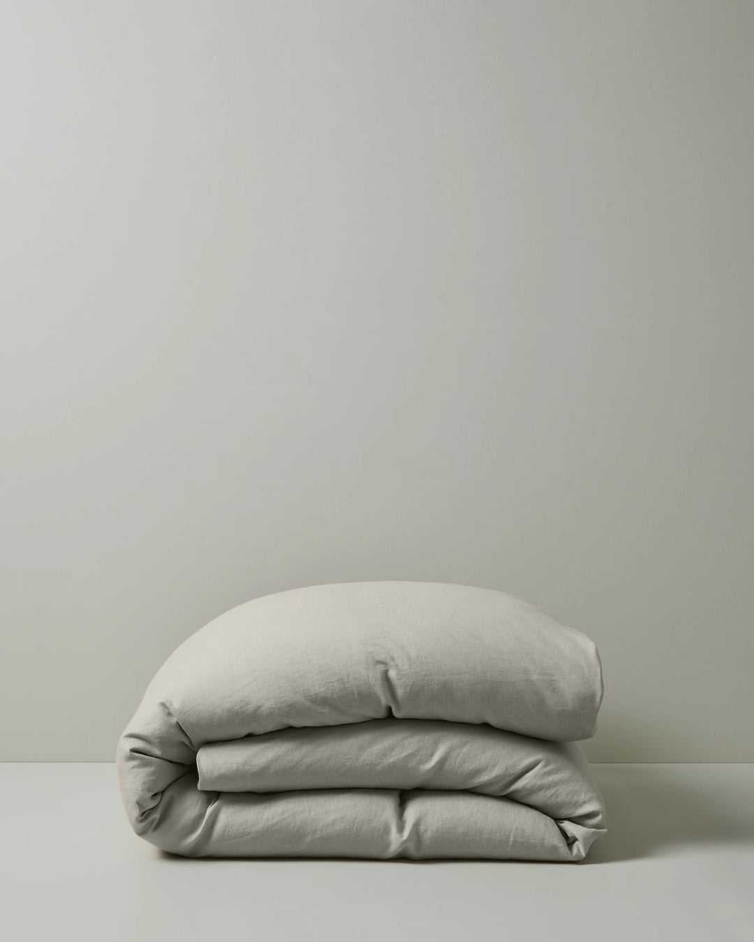 Ravello Quilt Cover in bone European linen, folded to show soft preiwashed texture and relaxed drape, by Weave Home