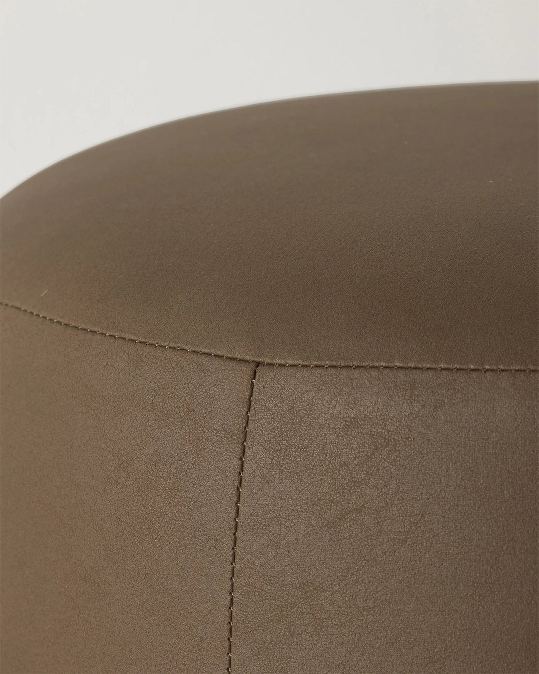 Landro Mocha ottoman detail view, showing soft polyester leather-look upholstery with subtle grain texture and blanket stitch seaming by Weave Home