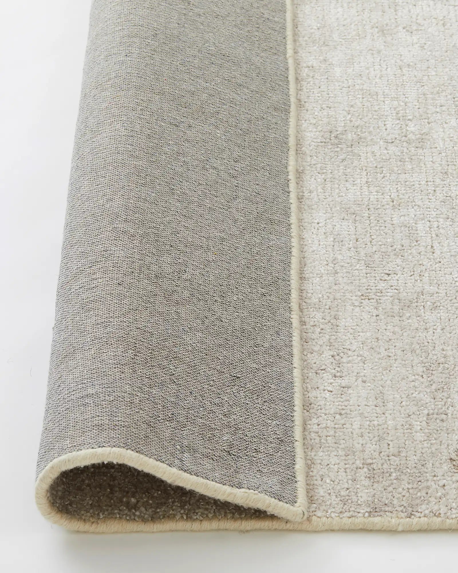 Almonte Oyster rug detail showing thick woven bamboo silk pile with cream backing and hand-knotted construction by Weave Home