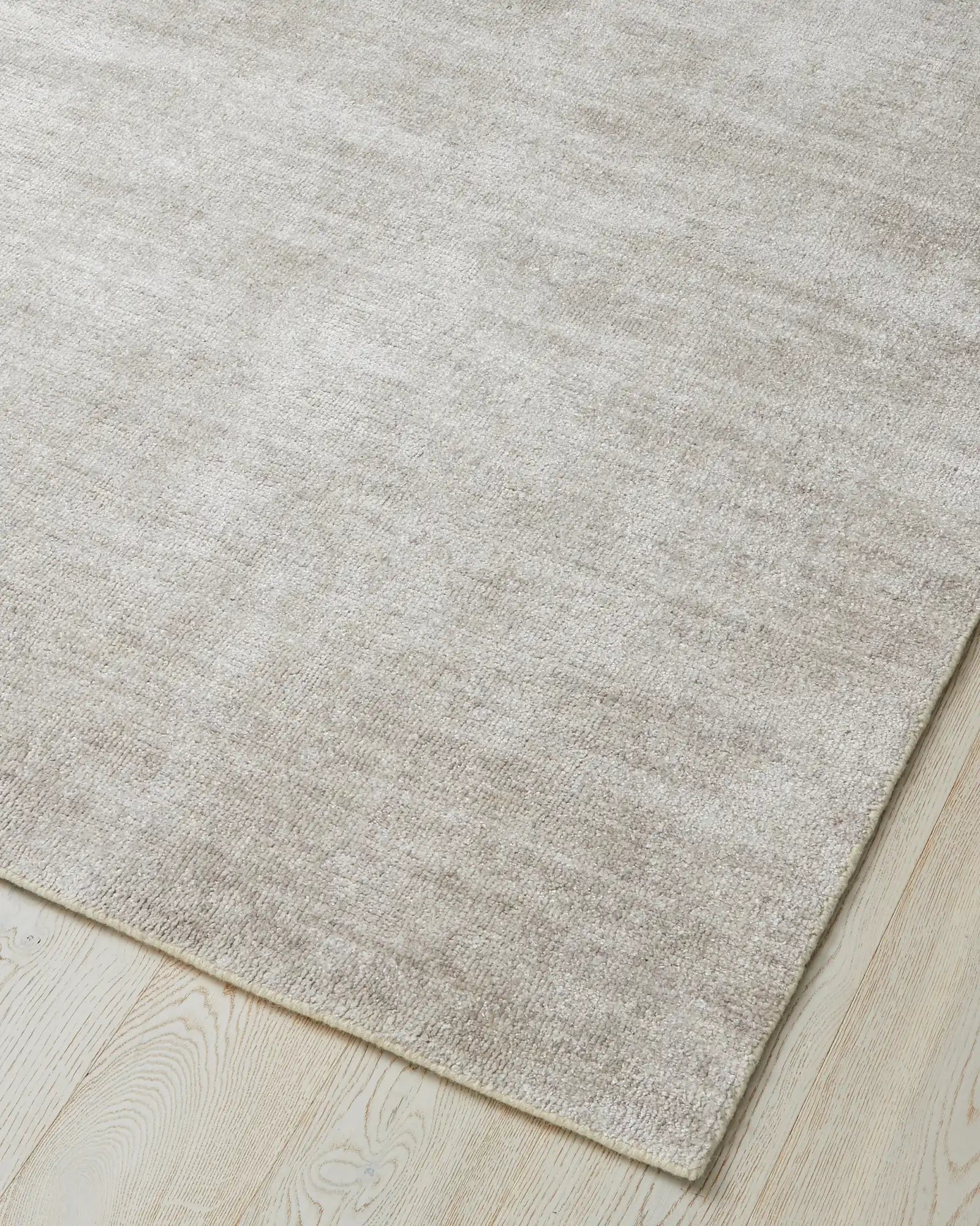 Almonte Oyster rug, woven bamboo silk low-traffic rug in subtle grey-brown, corner detail showing soft loom-knotted texture by Weave Home