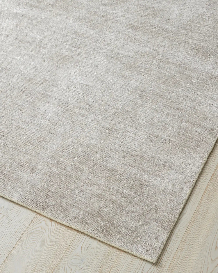 Almonte Oyster rug, woven bamboo silk low-traffic rug in subtle grey-brown, corner detail showing soft loom-knotted texture by Weave Home