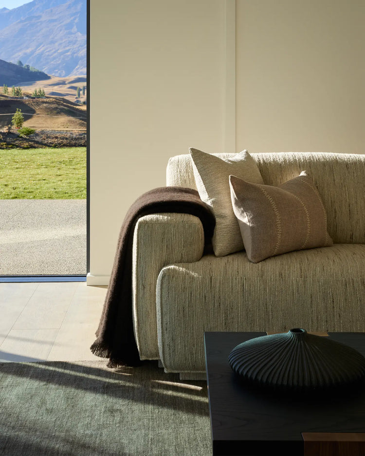 Hyde Cocoa woven wool blend throw in rich chocolate brown, displayed draped over a neutral upholstered sofa by Weave Home