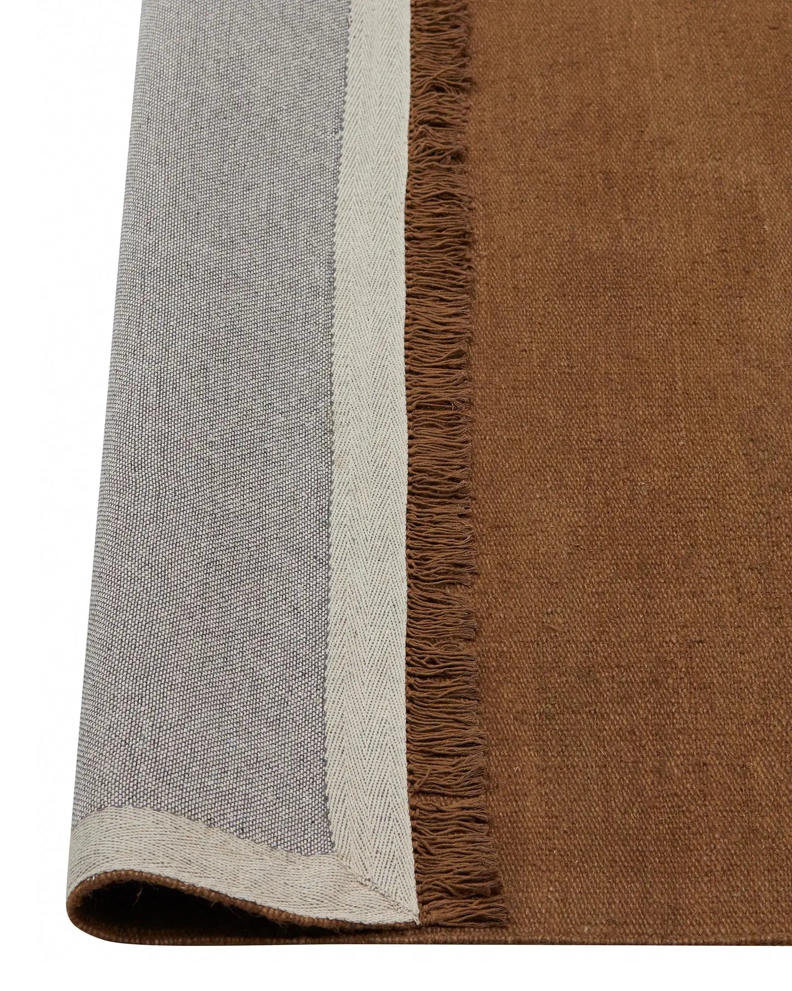 Emilio Toffee linen rug detail, showing flat-weave construction with fringe border and warm golden brown finish by Weave Home
