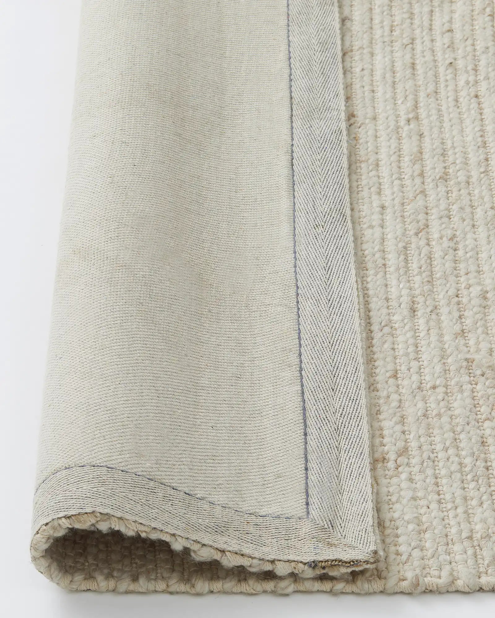 Andes Sandstorm rug detail showing ribbed wool cotton weave, natural cream tone, with full cotton backing and edging by Weave Home