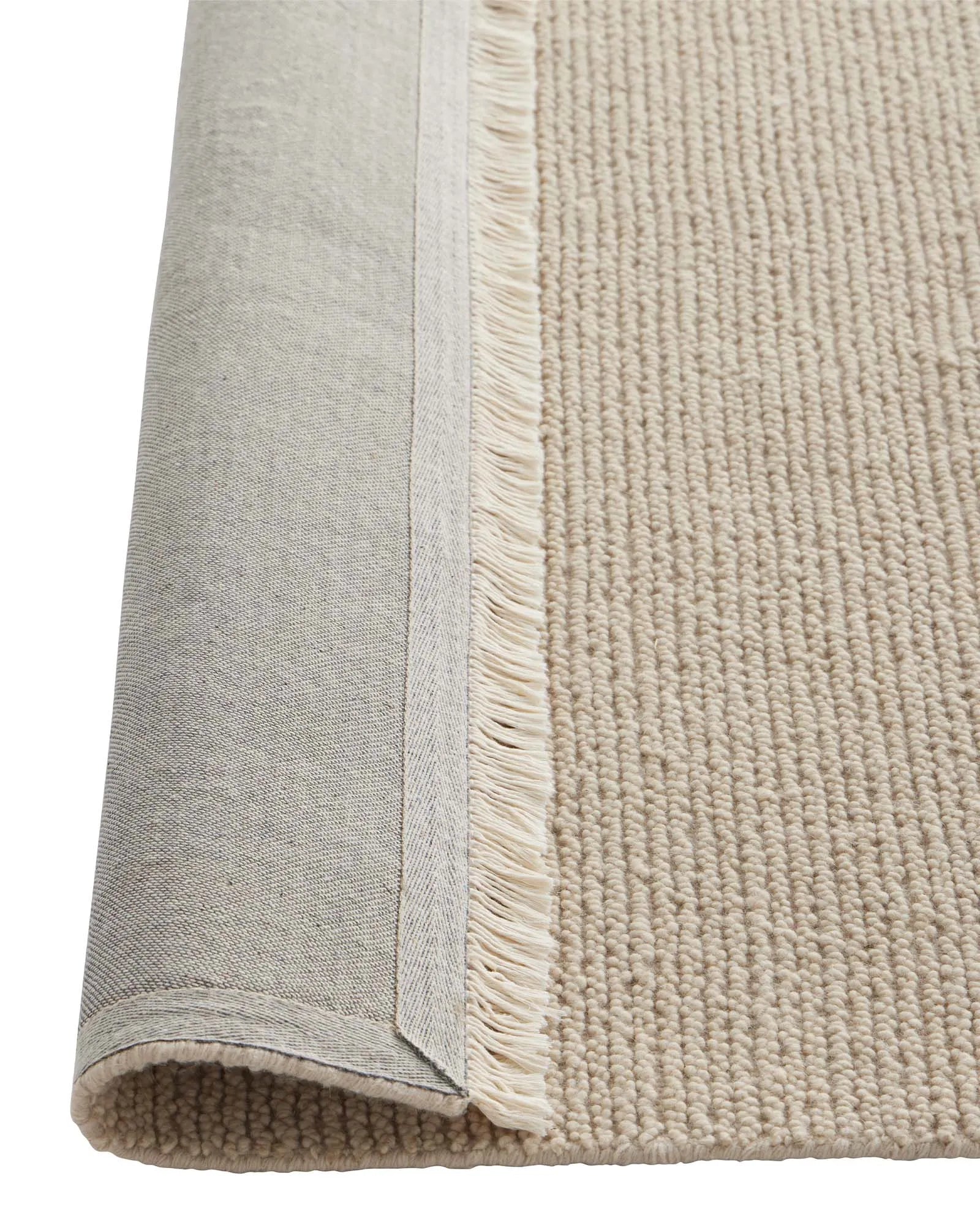 Fabien Stone textured wool rug detail showing chunky loop pile ribbed weave and cream fringe edge by Weave Home