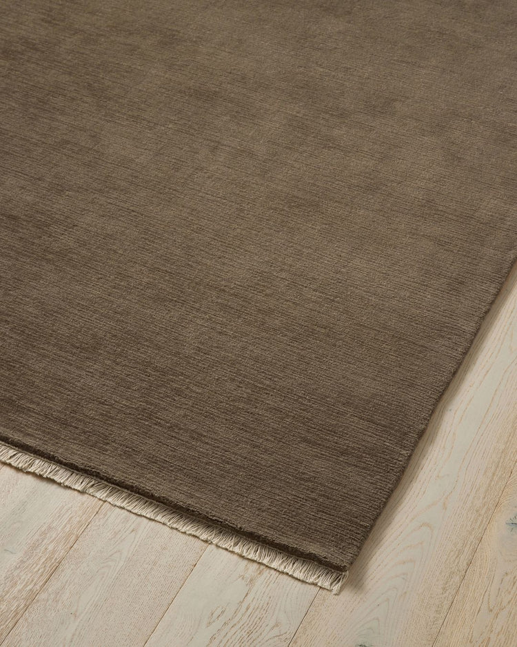 Alessandre Taupe hand-woven wool rug with fringe edge detail on light wood floor by Weave Home
