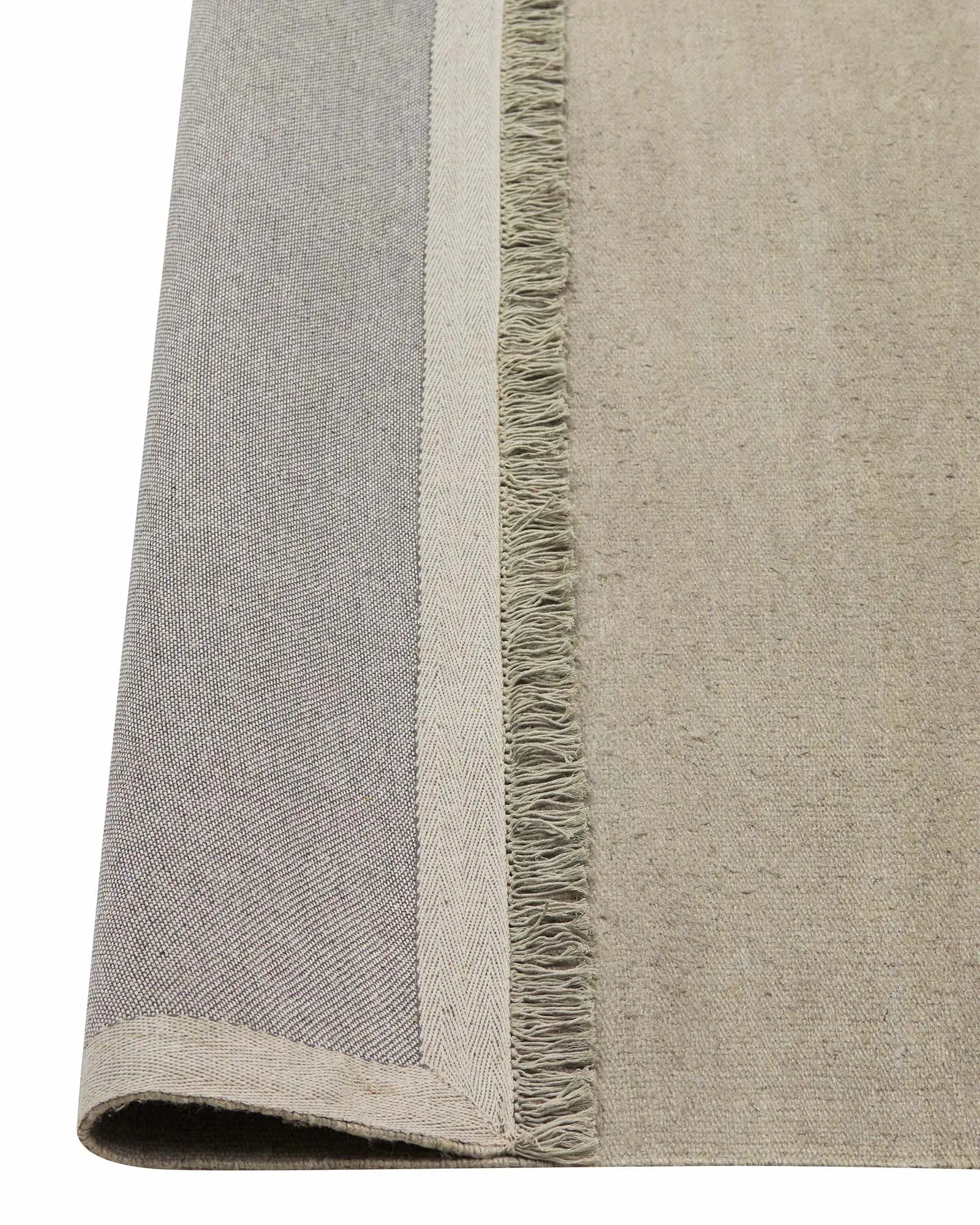 Emilio Oyster linen rug detail view, showing fringe border and flat-weave texture in pale grey by Weave Home