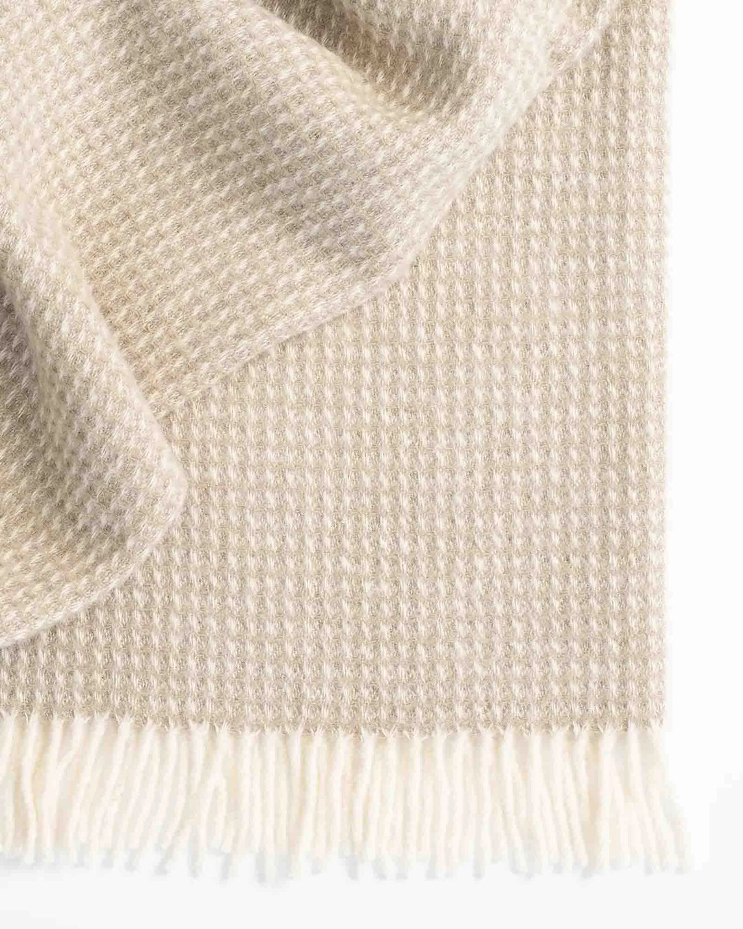 Breckon Hazel waffle weave wool throw in warm neutral, showing textured weave and cream fringe detail by Weave Home