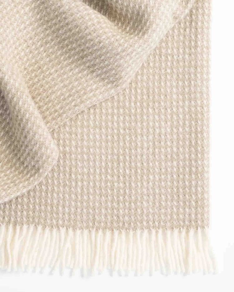 Breckon Hazel waffle weave wool throw in warm neutral, showing textured weave and cream fringe detail by Weave Home