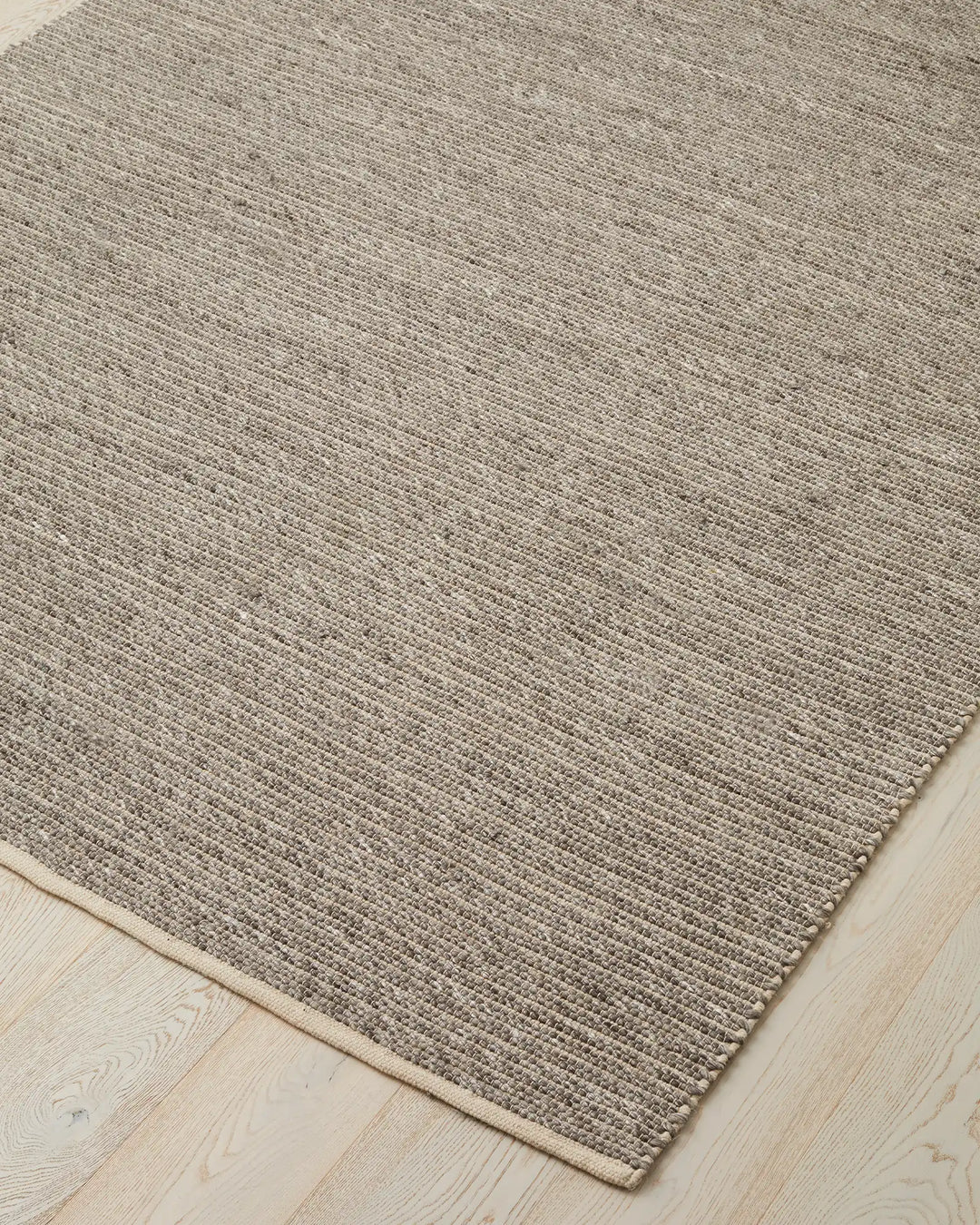 Andes Feather rug corner detail, wool-cotton blend with ribbed weave texture and natural cotton edging by Weave Home