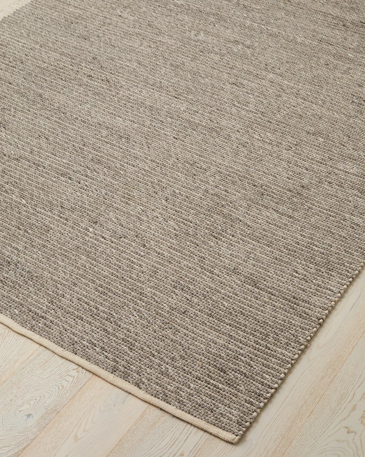 Andes Feather rug corner detail, wool-cotton blend with ribbed weave texture and natural cotton edging by Weave Home