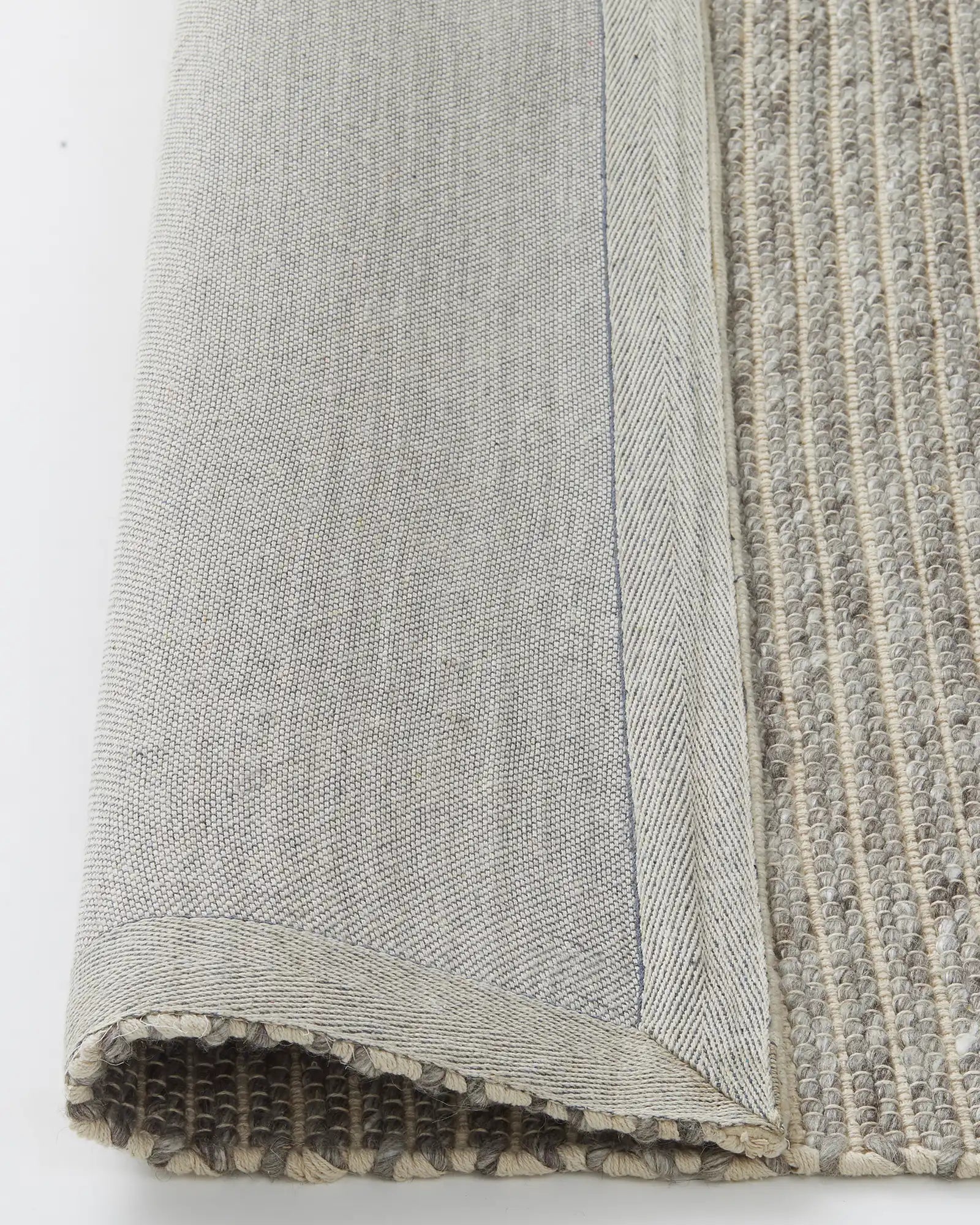 Andes Feather rug detail view showing ribbed wool-cotton weave texture with cotton backing and frayed edge by Weave Home