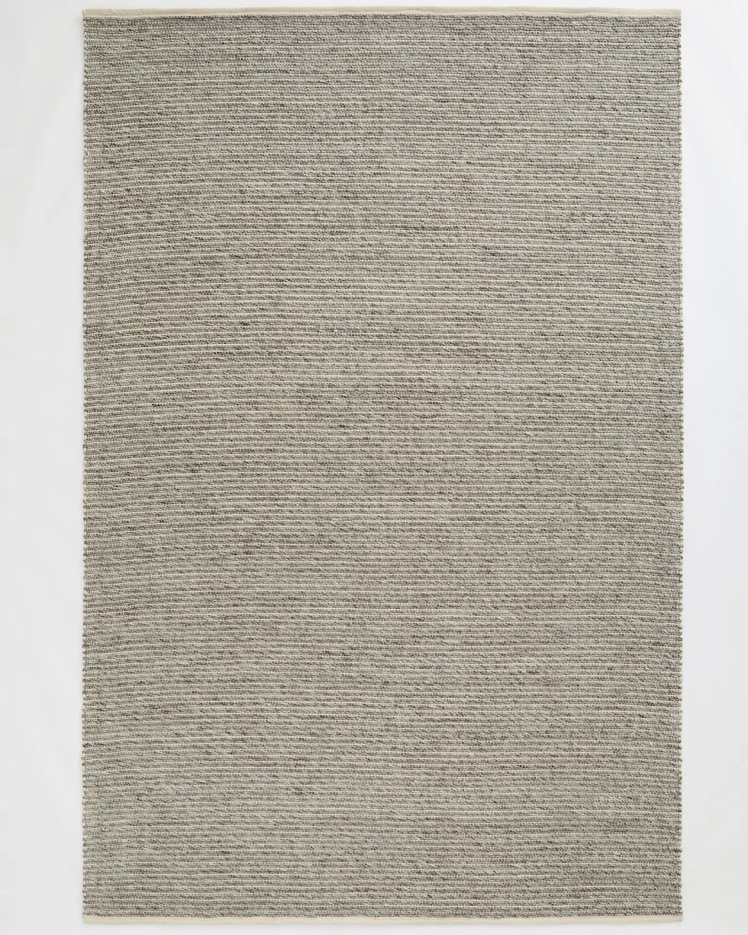 Andes Feather wool-cotton blend rug in soft grey, hand-woven with ribbed texture and cotton edging, by Weave Home