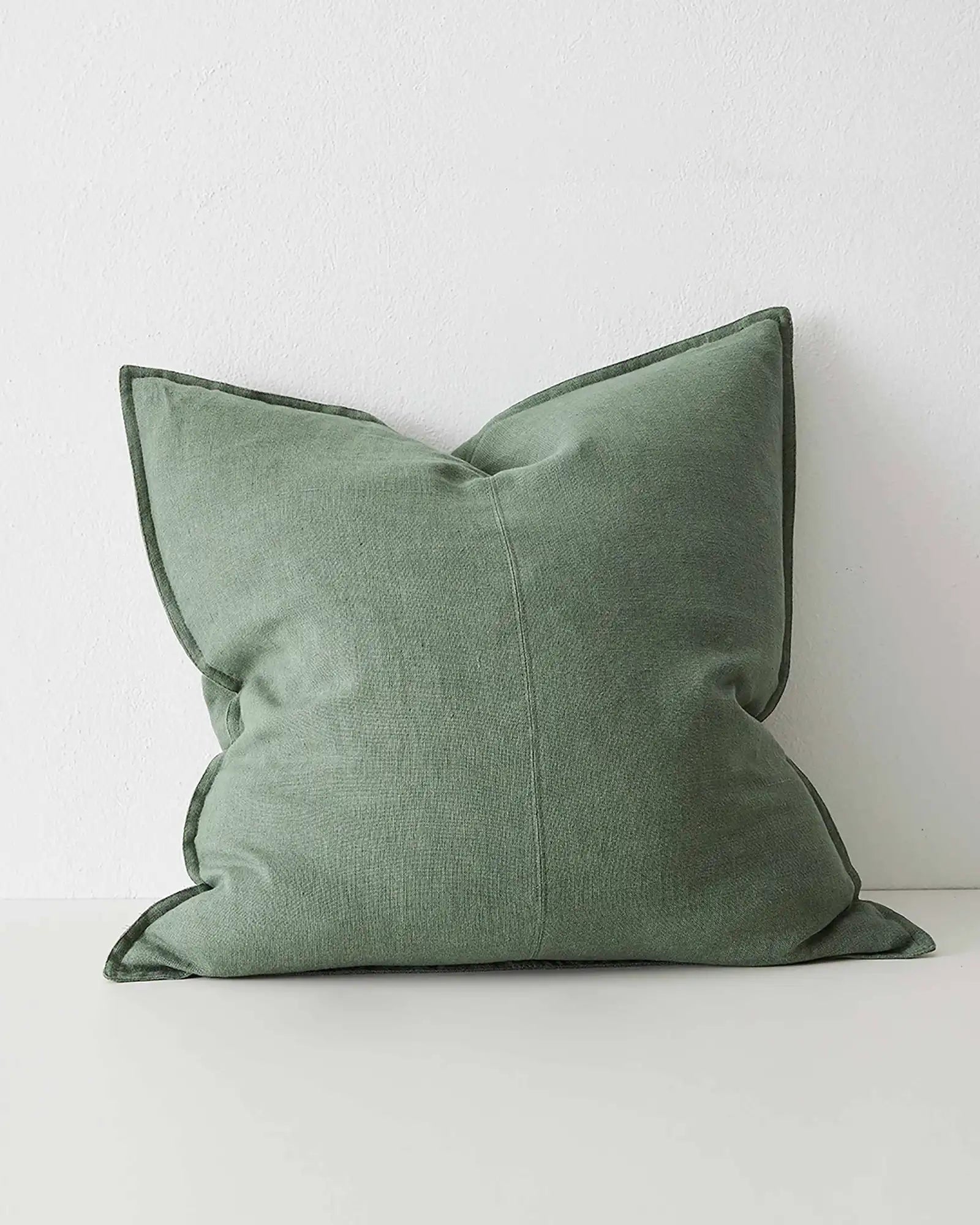 Como Juniper 60x60 linen cushion in cool-toned medium green with piped edge detail, front view by Weave Home