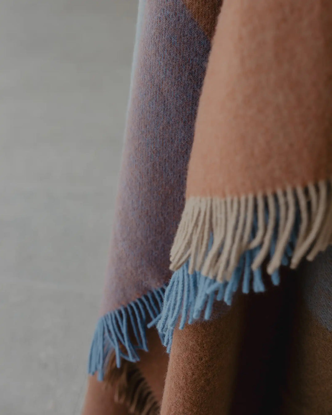 Brookside Ocean wool throw detail, showing fringed edge in cream and cornflower blue with oak and rust tones by Weave Home