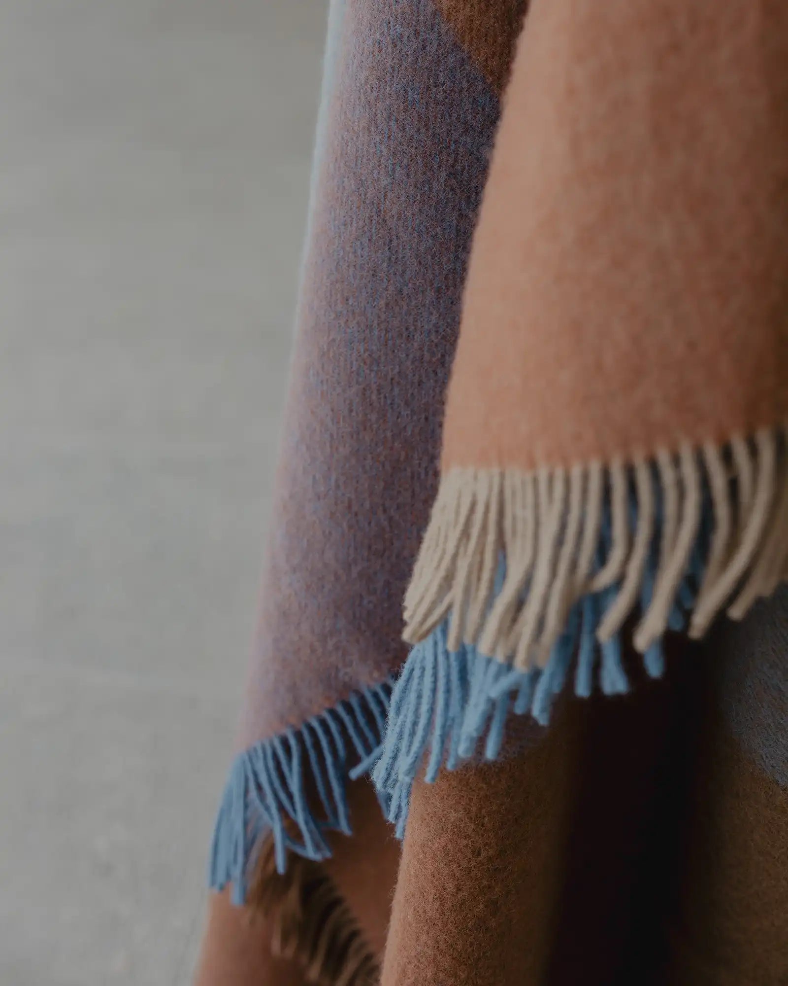 Brookside Ocean wool throw detail, showing fringed edge in cream and cornflower blue with oak and rust tones by Weave Home