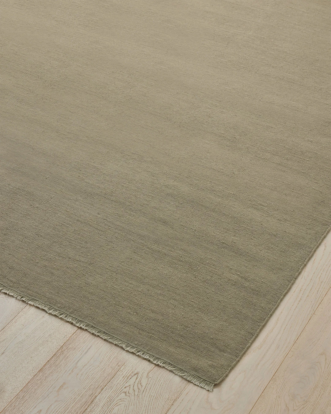 Jacqueline Pumice hand-woven wool rug in soft taupe grey with sage green undertones, flatweave construction detail by Weave Home