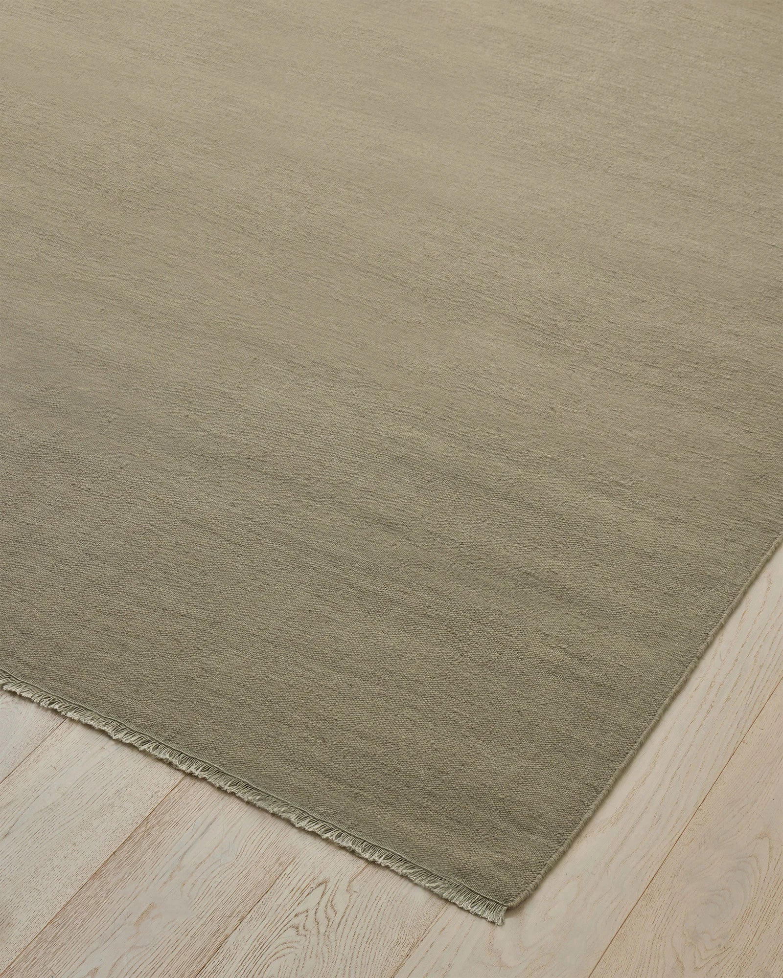 Jacqueline Pumice hand-woven wool rug in soft taupe grey with sage green undertones, flatweave construction detail by Weave Home