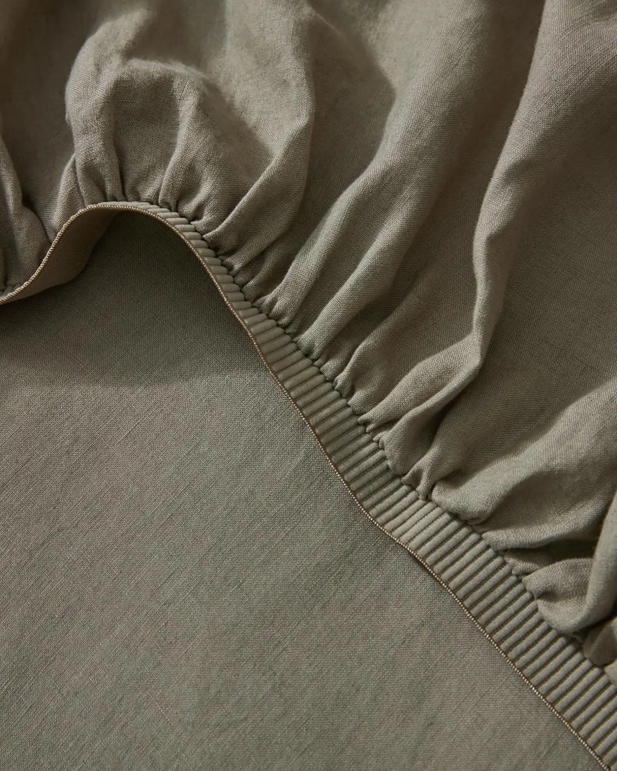Ravello Fitted Sheet in caper, detail view of elastic binding and stitched seam by Weave Home
