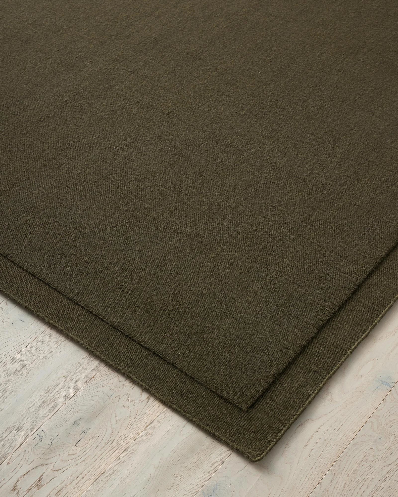 Cassio Jasper rug in deep olive, NZ wool loop pile with serged edge detail by Weave Home