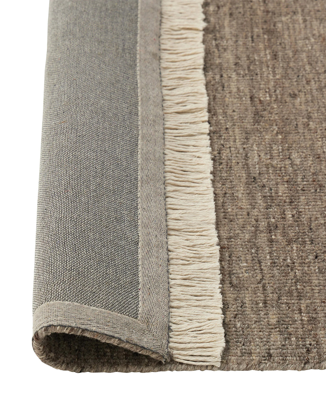 Anton Ash wool rug detail, showing soft grey with warm undertones, cut and loop pile texture, and cream cotton fringe border by Weave Home