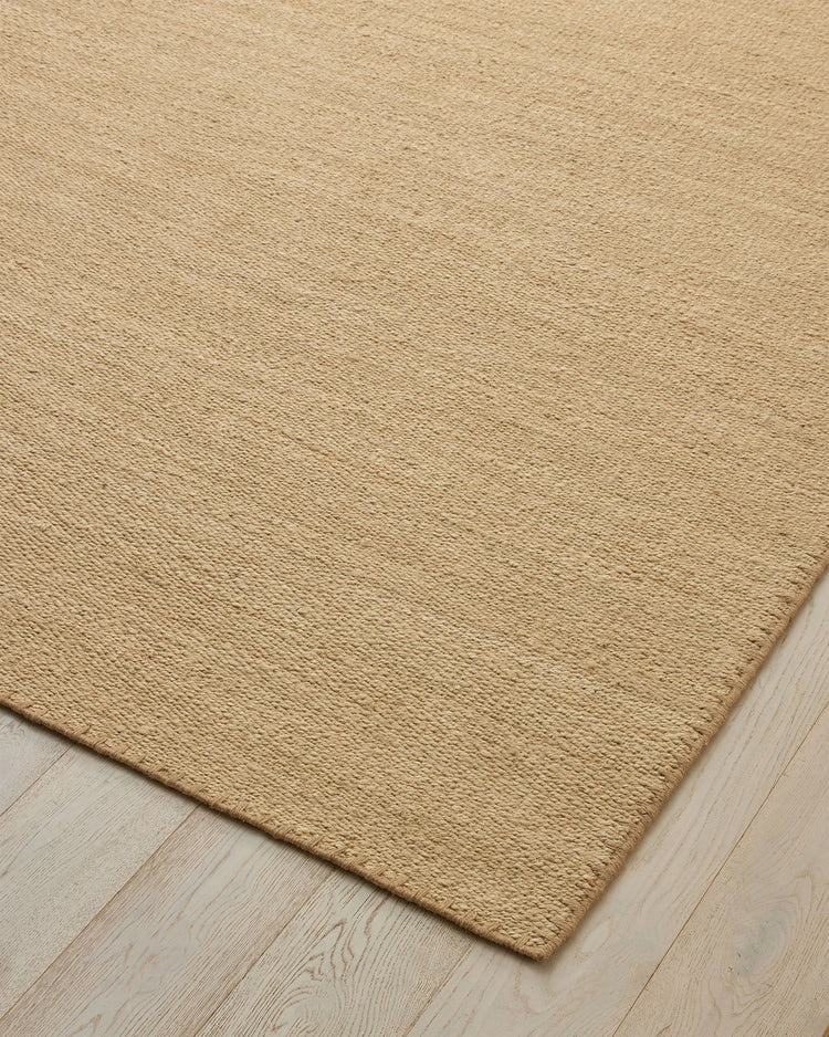 Monroe Oat high-traffic rug in warm sand neutral, showing woven polyester texture with blanket stitch border detail by Weave Home