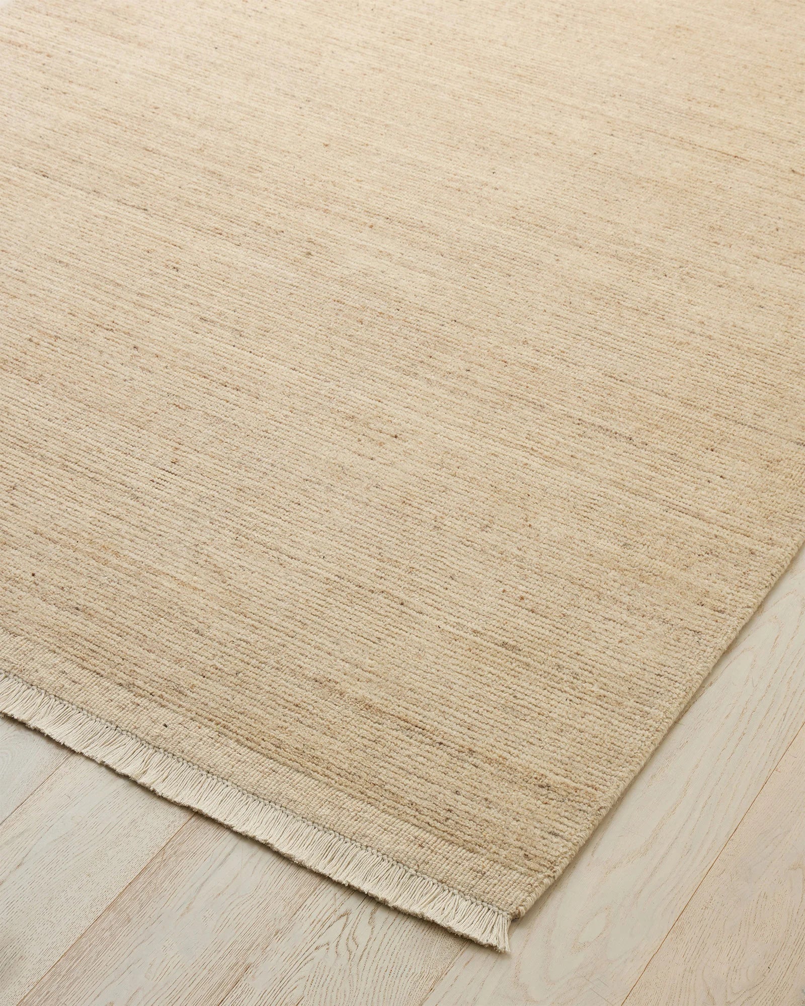 Anton Sand hand-woven wool rug with ribbed texture, warm neutral tone and off-white cotton fringe detail by Weave Home