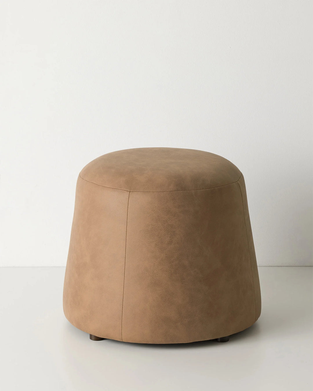 Landro Toffee ottoman, warm brown soft polyester with leather grain texture and domed silhouette, by Weave Home