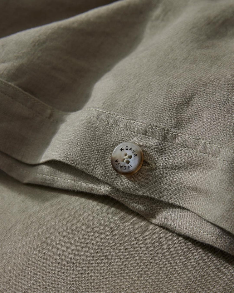 Ravello Quilt Cover Caper close-up detail of branded button closure on soft French flax linen by Weave Home