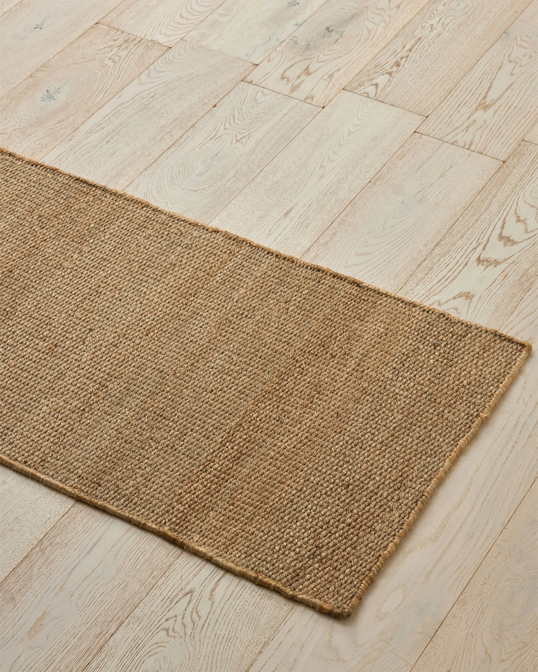 Ivano Wheat jute door mat in warm beige, handwoven with textured surface, 65x120cm, laid on light timber floor by Weave Home