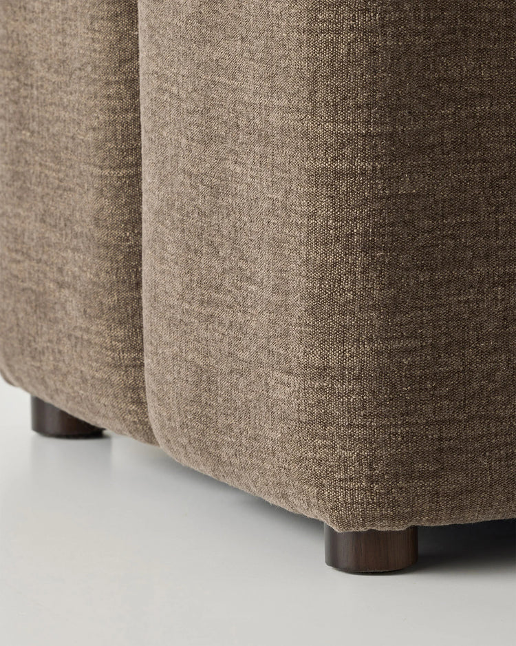 Campello Bark ottoman detail view, showing chocolate brown micro chenille upholstery with textured weave and dark wood feet by Weave Home
