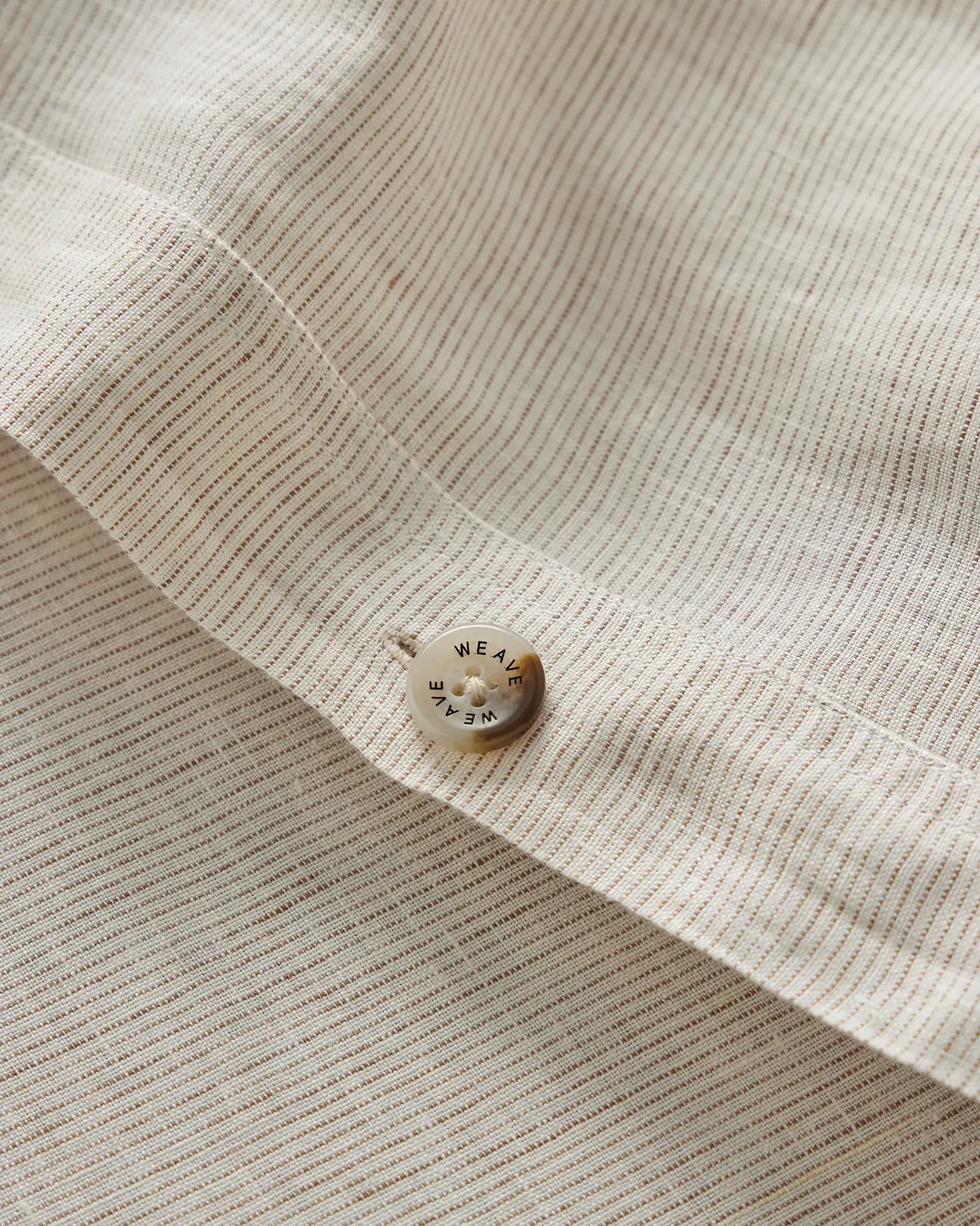 Sova Quilt Cover in Savanna Pinstripe, close-up detail of woven linen texture with branded button by Weave Home